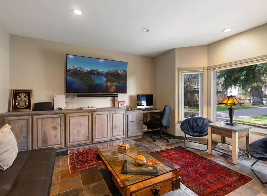 This living room features a large flat-screen TV mounted above a rustic wooden entertainment center, perfect for movie nights.