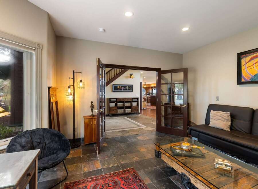 Step into this inviting living space featuring a cozy black armchair and a sleek black sofa, perfect for relaxation.