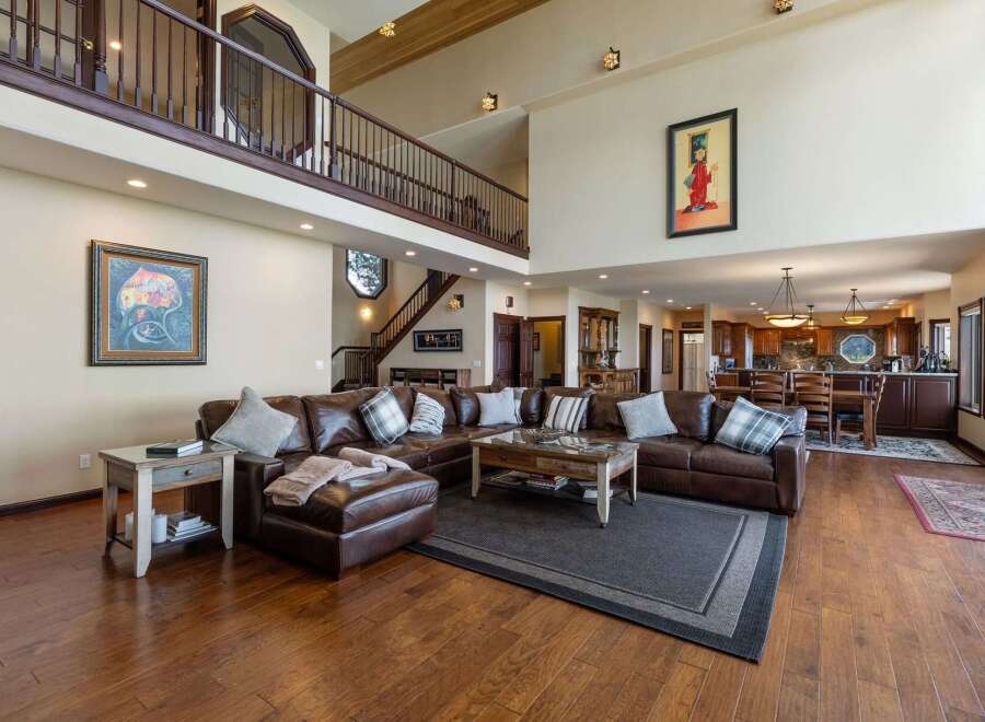 Experience luxurious living in this expansive great room, featuring a grand two-story layout and a stunning leather sectional.