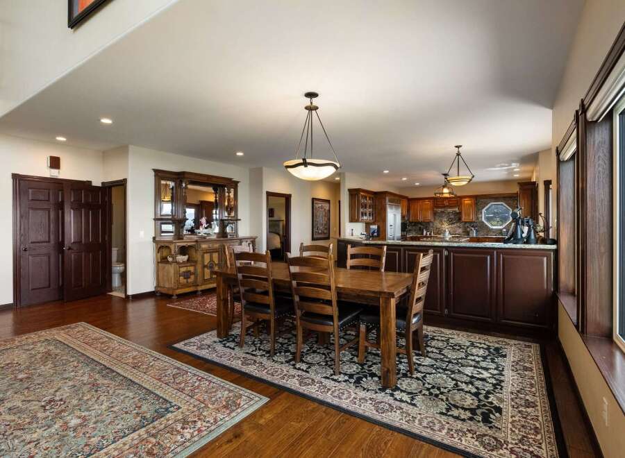 This spacious open-concept dining and kitchen area features a large wooden dining table with seating for six, perfect for family gatherings.