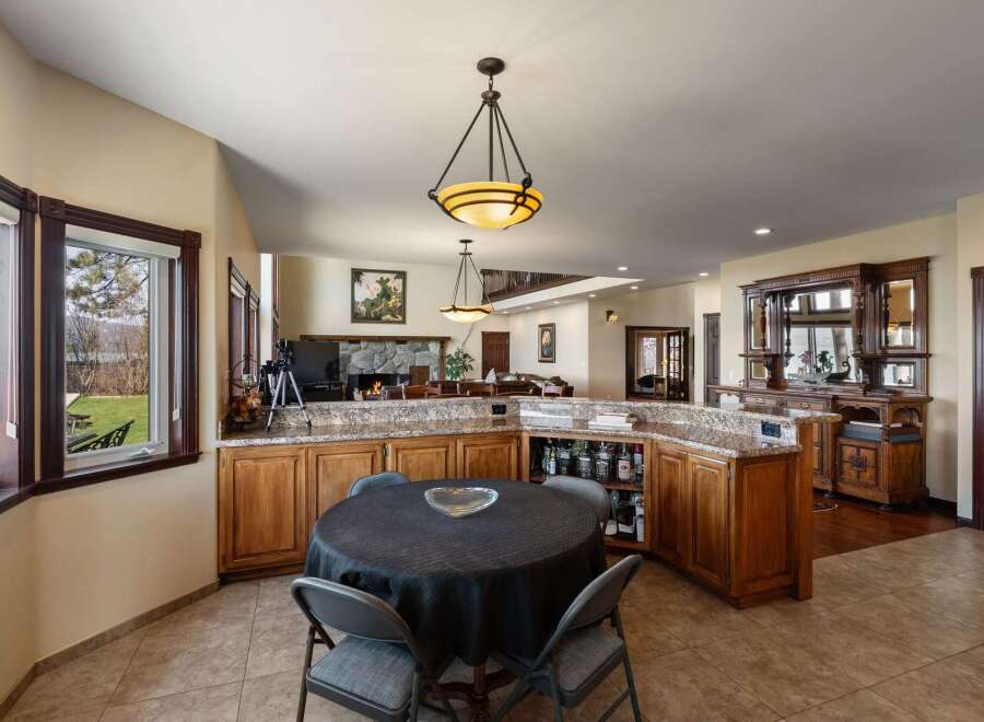 This spacious home features an open-concept living area with a large stone fireplace and a well-appointed bar perfect for entertaining.