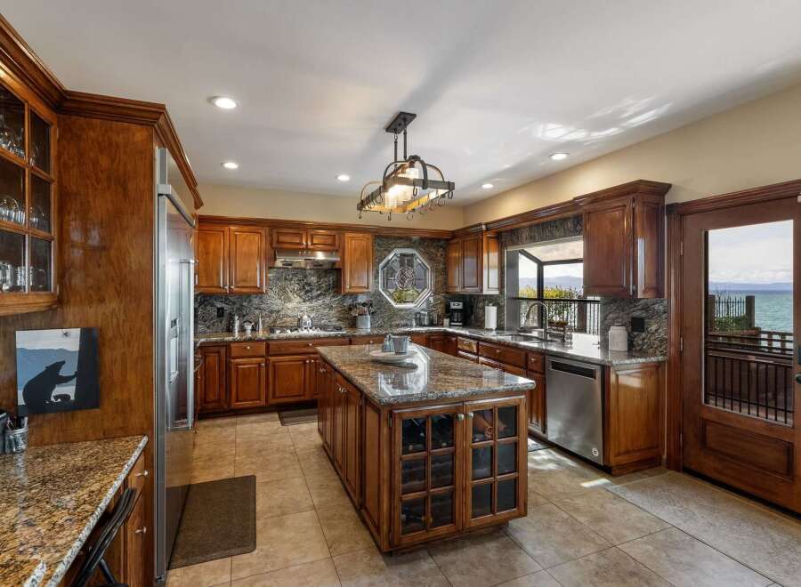 Experience breathtaking lake views from this stunning kitchen, featuring rich cherry wood cabinetry and granite countertops.