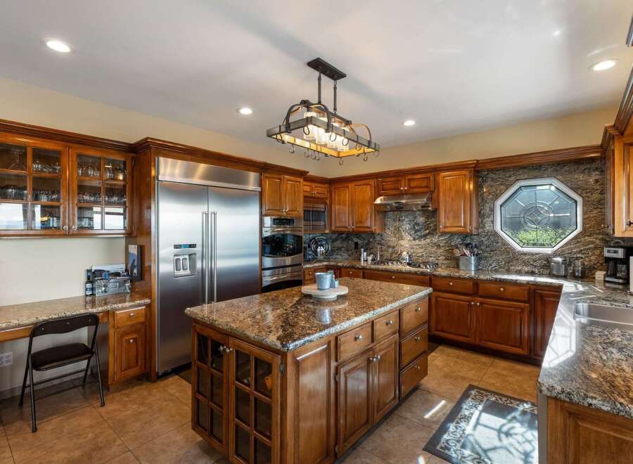 Experience luxury in this stunning kitchen featuring custom wood cabinetry and granite countertops.