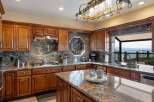Experience breathtaking ocean views from this stunning kitchen, featuring rich wood cabinetry and elegant granite countertops.