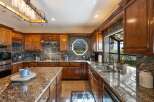 Experience luxury in this stunning kitchen featuring rich wood cabinetry and exquisite granite countertops.