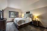 Experience rustic charm in this inviting bedroom, featuring a queen-size bed with a distressed wood headboard and cozy bedding.