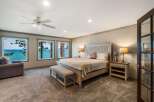 Experience breathtaking lake views from this luxurious master bedroom, featuring a spacious king-size bed and a comfortable seating area.