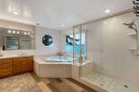 Experience luxury in this stunning bathroom featuring a spacious corner jacuzzi tub with breathtaking lake views.
