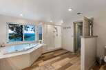 Indulge in luxury with this stunning bathroom featuring a spacious jacuzzi tub offering breathtaking lake views.