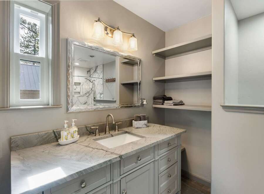 This beautifully appointed bathroom features a stunning marble vanity with a undermount sink and elegant brushed nickel fixtures.
