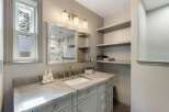 This beautifully appointed bathroom features a stunning marble vanity with a undermount sink and elegant brushed nickel fixtures.