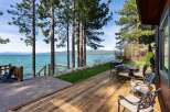 Enjoy breathtaking lake views from this stunning property featuring a spacious wooden deck perfect for outdoor entertaining.