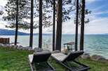 Enjoy breathtaking lake views from this stunning property, featuring two comfortable lounge chairs perfect for soaking up the sun.