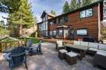 Experience luxury living in this stunning lakefront property, featuring a spacious wooden deck and a beautifully paved patio perfect for outdoor entertaining.