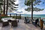 Enjoy breathtaking lake views from this stunning patio, complete with comfortable wicker sectional seating and a dining table.