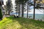 Experience luxurious lakeside living with this stunning property featuring a spacious deck and manicured lawn leading to the water's edge.