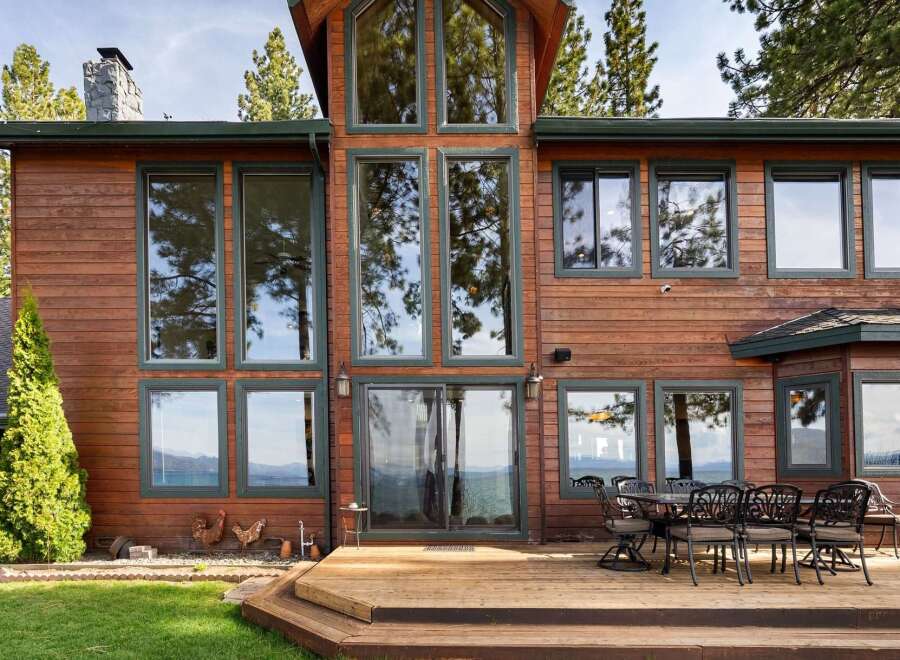 Experience luxury living in this stunning lakefront property, featuring expansive windows that offer breathtaking views of the water and surrounding mountains.