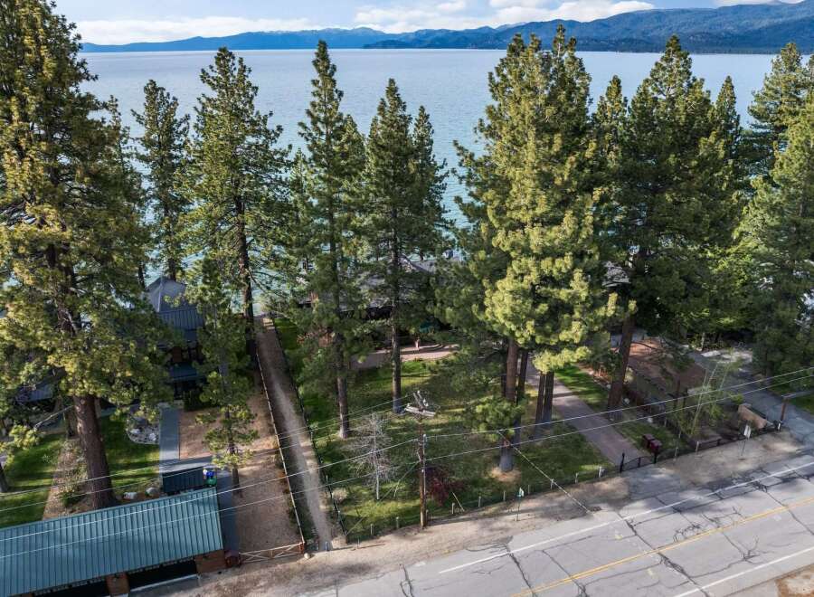 Experience serene lakefront living with this stunning property, nestled amongst mature pine trees and offering breathtaking views of the water and distant mountains.