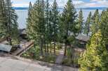 Experience serene lakefront living with this stunning property, nestled amidst towering pine trees and offering breathtaking views of the water.