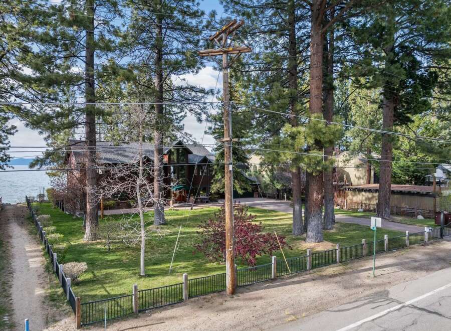 Experience lakeside living in this stunning property, featuring a spacious home nestled among mature trees with breathtaking water views.