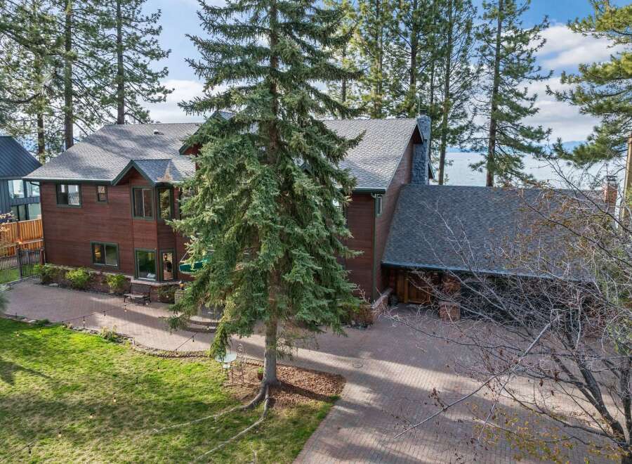 Experience luxury living in this stunning lakefront property, nestled amidst towering pine trees.