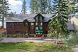 Experience luxury living in this stunning lakefront property, featuring a grand wooden exterior and expansive windows offering breathtaking water views.