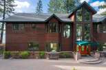 Experience luxury living in this stunning lakefront property, boasting a grand wooden exterior and expansive windows that capture breathtaking views.