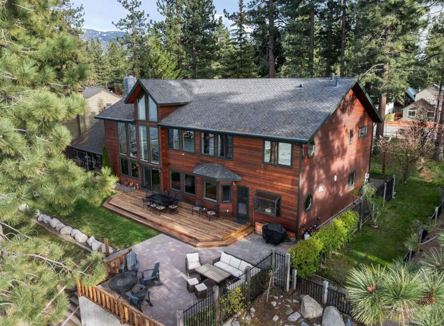 Experience luxury living in this stunning lakefront property, boasting a spacious wooden deck perfect for entertaining and a beautifully landscaped backyard.