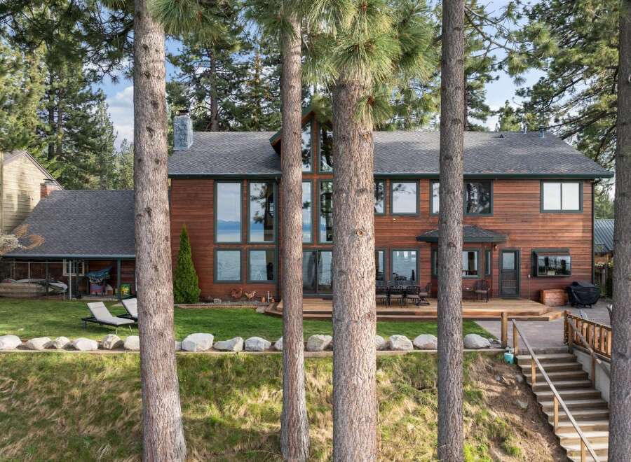 Experience luxury lakeside living in this stunning wood-sided home, featuring expansive windows that capture breathtaking water views.