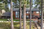 Experience luxury lakeside living in this stunning wood-sided home, featuring expansive windows that capture breathtaking water views.