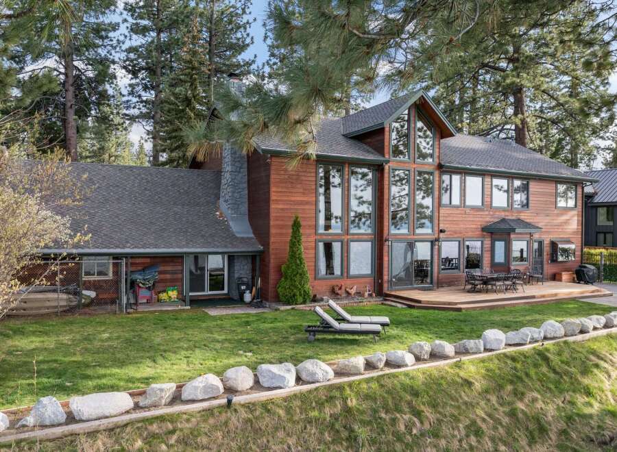 Experience luxurious lakeside living in this stunning wood-sided home, featuring expansive windows that capture breathtaking water views.