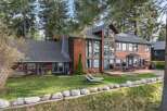 Experience luxurious lakeside living in this stunning wood-sided home, featuring expansive windows that capture breathtaking water views.