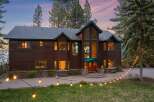 Experience luxury living in this stunning lakefront property, featuring a grand wooden exterior and expansive windows that capture breathtaking views.