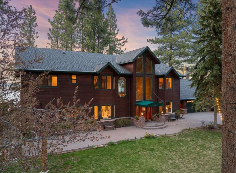 Experience luxury living in this stunning custom-built home, nestled amidst towering pine trees.