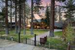Experience luxury living in this stunning mountain home, nestled amongst towering pine trees and featuring a charming string light ambiance.