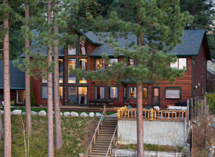 Experience luxurious living in this stunning multi-level wooden home, nestled amongst towering pine trees.