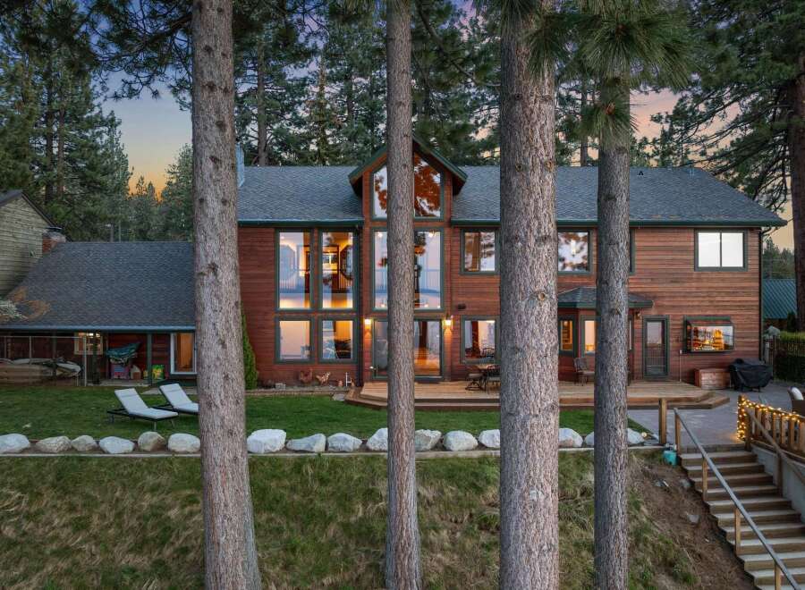 Experience luxury living in this stunning lakefront home, nestled amongst towering pine trees.