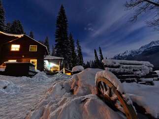 Experience the magic of a winter wonderland with this charming log cabin nestled amidst snow-covered pines.