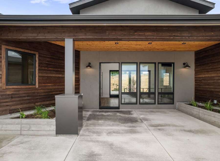 Experience modern living in this stunning home featuring a striking exterior with rich wood paneling and sleek concrete accents.