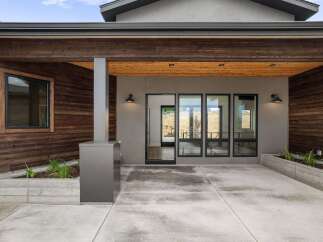 Experience modern living in this stunning home featuring a striking exterior with rich wood paneling and sleek concrete accents.