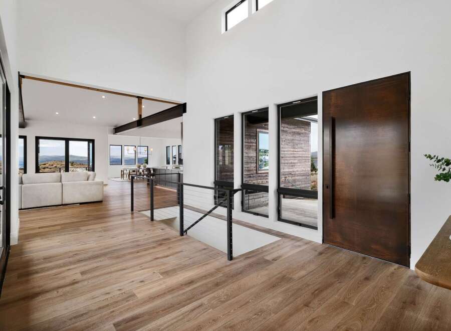 Experience modern luxury in this stunning home featuring an open-concept living space with soaring ceilings and exposed beams.