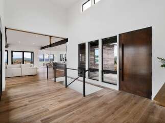 Experience modern luxury in this stunning home featuring an open-concept living space with soaring ceilings and exposed beams.