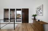 Step into a modern entryway featuring a striking dark wood door and expansive windows that flood the space with natural light.