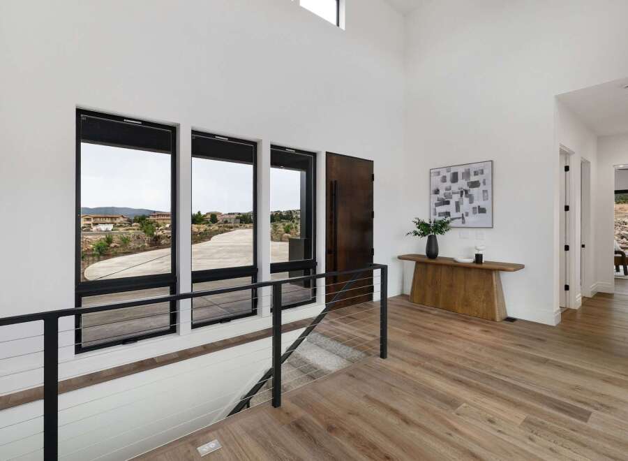 Experience modern luxury in this stunning entryway featuring expansive windows that flood the space with natural light and offer breathtaking views.
