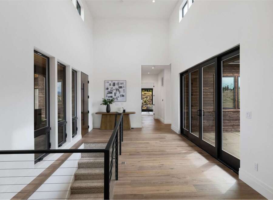Experience modern luxury in this stunning entryway featuring soaring ceilings and abundant natural light.