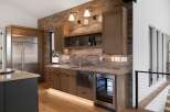 Experience luxury living with this modern kitchen featuring a sleek stainless steel refrigerator and a built-in wine cooler.