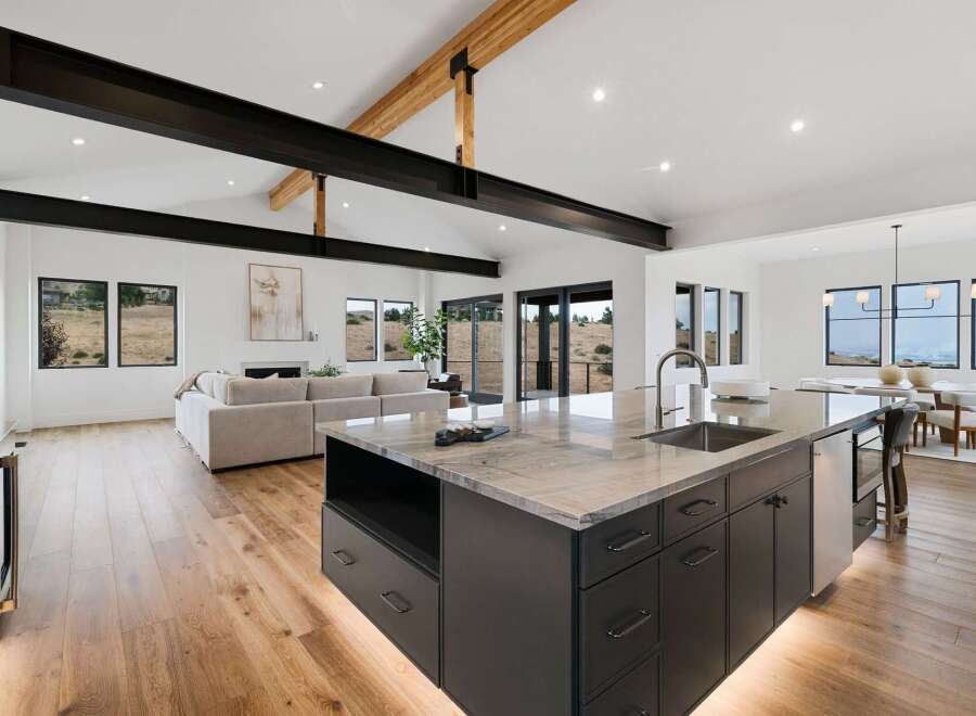Experience modern luxury in this open-concept living space, featuring a gourmet kitchen with a stunning marble island and sleek dark cabinetry.