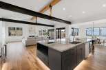 Experience modern luxury in this open-concept living space, featuring a gourmet kitchen with a stunning marble island and sleek dark cabinetry.