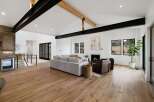 Experience modern luxury in this stunning living room, featuring soaring vaulted ceilings with exposed black steel beams and natural wood accents.