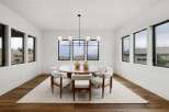 Experience elegant dining in this modern space, featuring a round wooden table surrounded by plush white chairs.